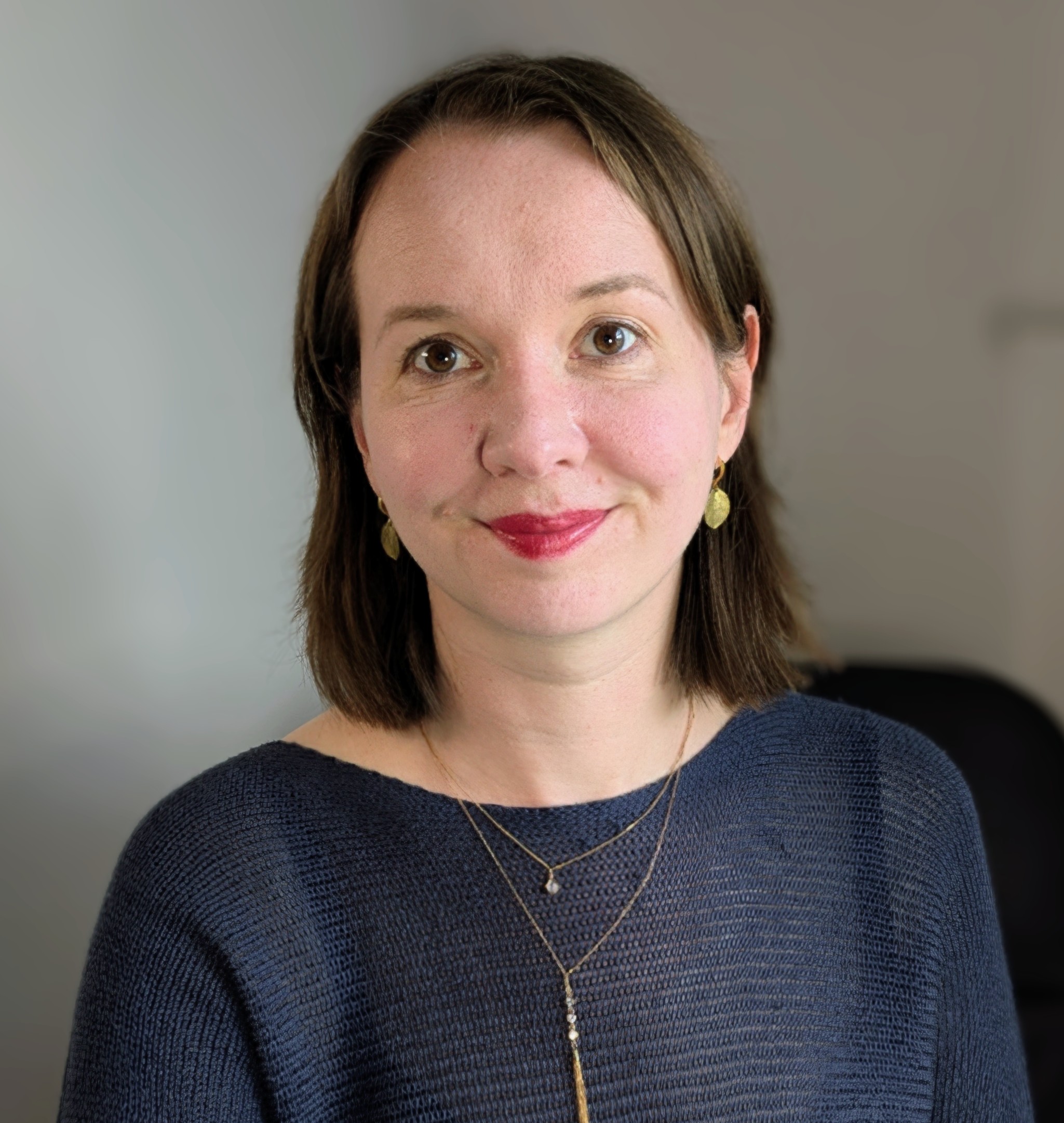 A photo of Olga Cherrington, Nurture Neuroscience sleep coach. Olga is a white woman with shoulder-length brown hair.